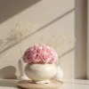 Delicate pink rose bouquet in white patterned vase with dried floral accents
