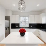 Vase of red roses on a kitchen island, elegant floral arrangement.