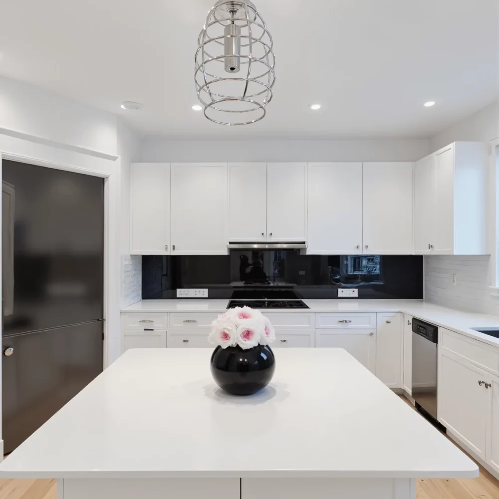 Contemporary kitchen with black glass backsplash and white-pink rose bouquet
