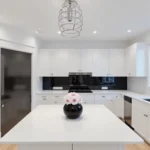 Contemporary kitchen with black glass backsplash and white-pink rose bouquet