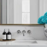 Elegant bathroom vanity with silver vase of blue roses and brass sconces