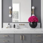 Contemporary bathroom with black vase of pink roses and gold fixtures