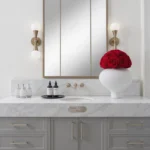 Modern bathroom with white marble countertop and red rose bouquet