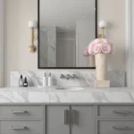 Modern bathroom with beige walls, gold sconces, and pink roses