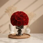 Minimalist floral arrangement with red roses in black and white marble vase