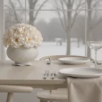 Serene dining table with white vase of cream flowers and snowy landscape