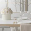 Minimalist dining table with white fabric flower centerpiece and monochrome forest scene