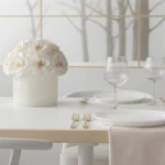 Minimalist dining table with white fabric flower centerpiece and monochrome forest scene