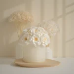 Soft-focused floral arrangement with white artificial flowers in beige vase