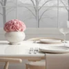 Elegant dining table with pink rose centerpiece and frosted tree-patterned windows