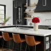 Stylish kitchen with black cabinetry, orange stools, and red roses