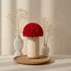Modern floral arrangement with red roses in speckled beige vase