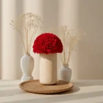 Modern floral arrangement with red roses in speckled beige vase