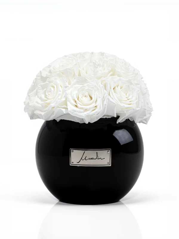 Luxury black ceramic vase with a refined cream lachaise label, showcasing pristine white roses in full bloom,