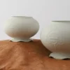 Two pale green ceramic vases with flower designs