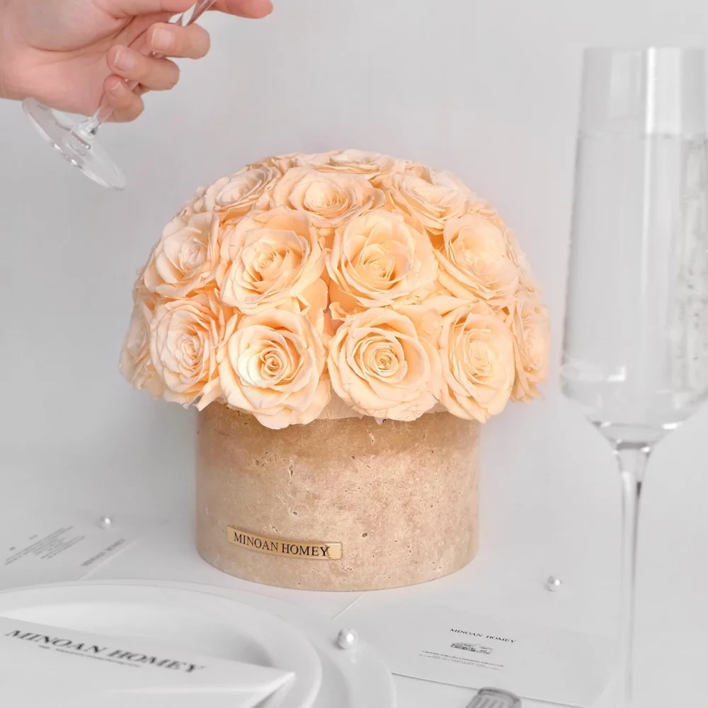 Cream spherical floral arrangement in beige vase with "MIDAS HONEY" label as hand pours water