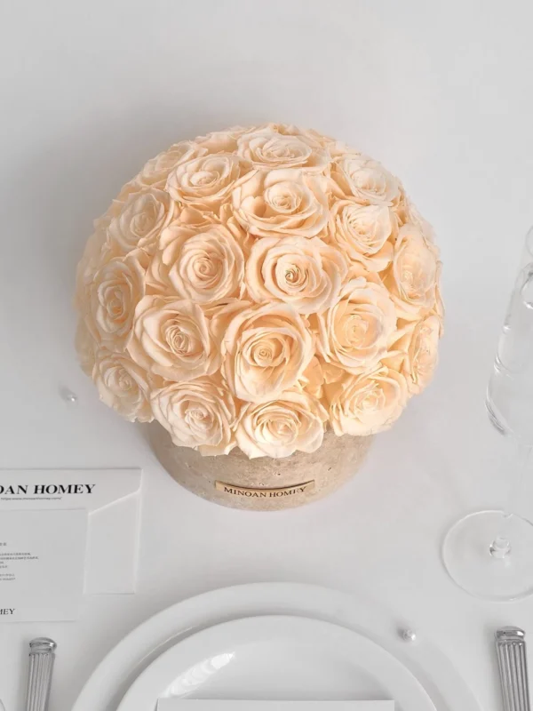 Minimalist elegant table setting with beige rose bouquet on cream box, white plate, and silverware