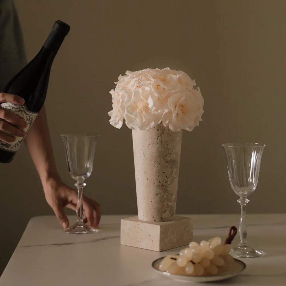 Minimalist table setting with beige stone vase of cream hydrangeas