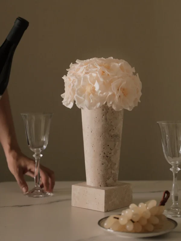 Minimalist table setting with beige stone vase of cream hydrangeas