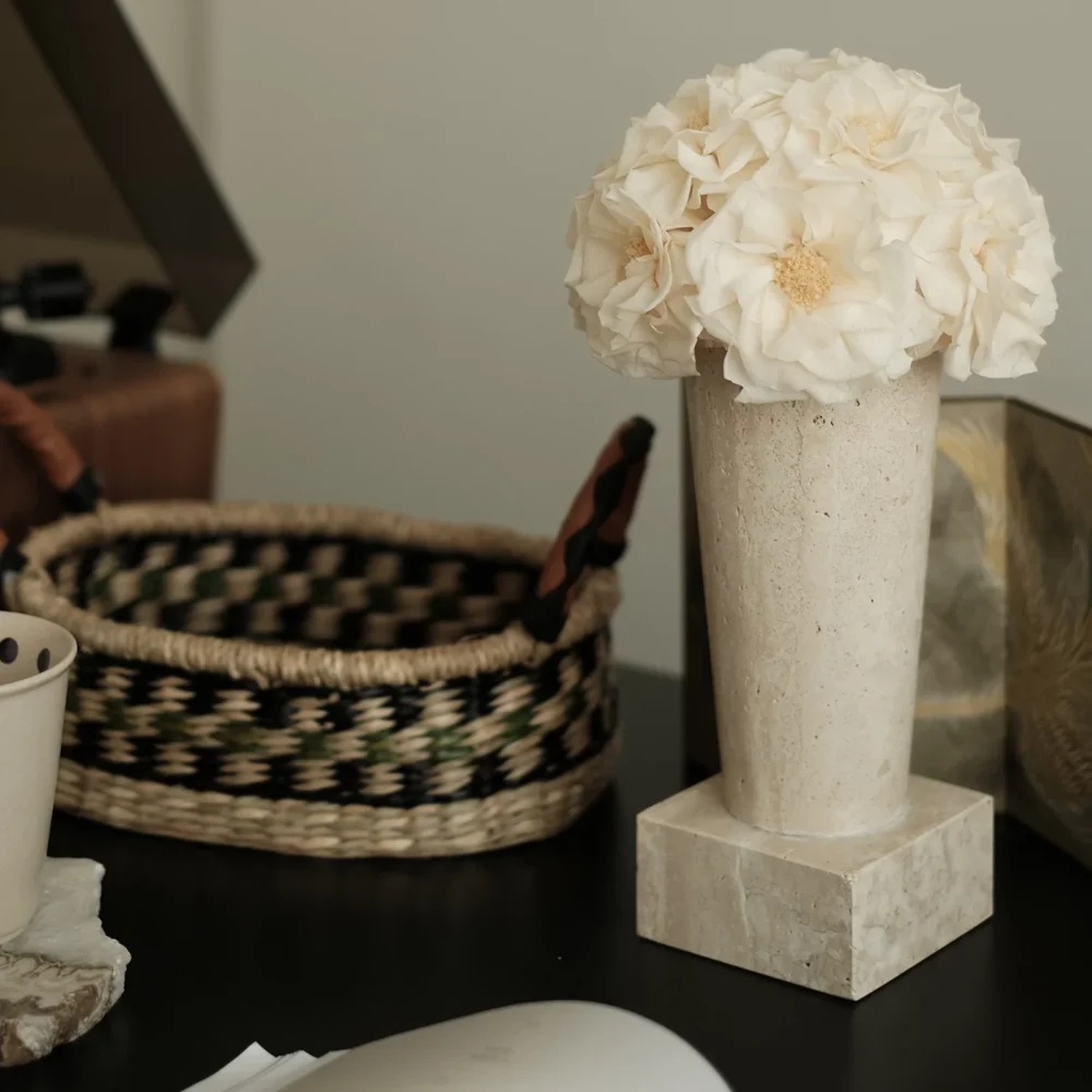 Minimalist interior with cream vase of white hydrangeas on marble stand