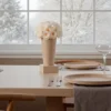 Scandinavian dining room with white flowers and snowy landscape backdrop