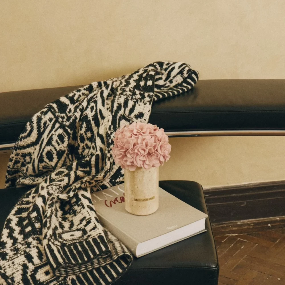 Black leather bench with vase of pink hydrangeas