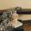 Black leather bench with vase of pink hydrangeas