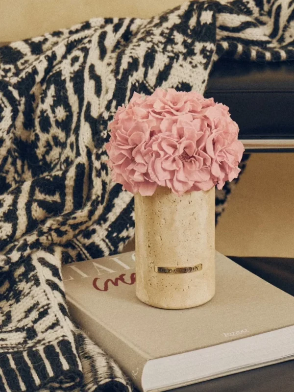 Black chair with beige vase of pink hydrangeas