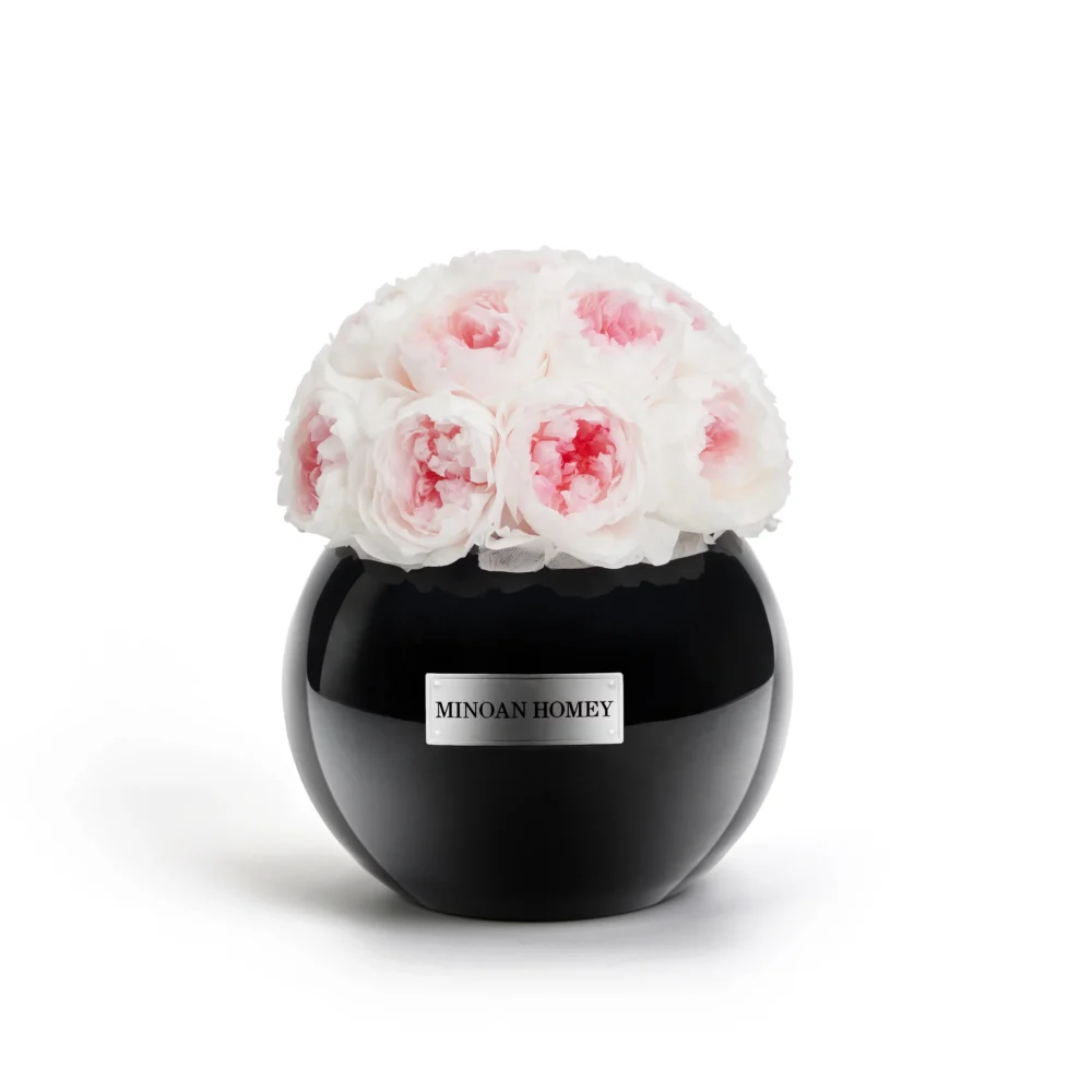 Black glossy vase labeled "MINGON HOMEY" containing bouquet of white roses with pink accents on white background