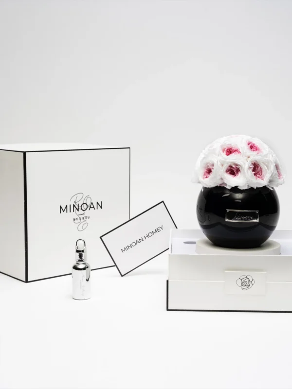 Minimalist elegant product display with black glass vase containing white roses with red tips and "Minox" branding