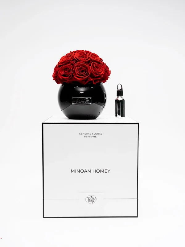 Minimalist elegant setup featuring black spherical glass vase with red roses on "MINDAN HONEY" labeled box