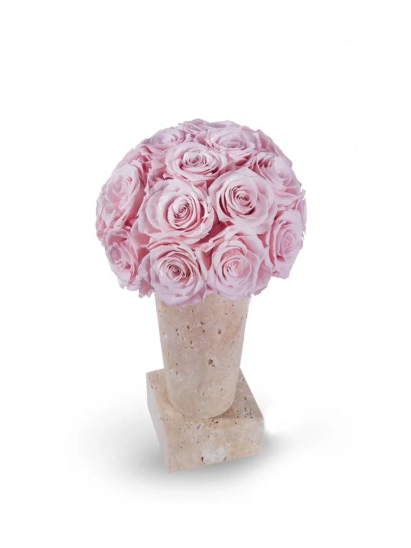 Bouquet of pink roses densely packed in light beige textured vase on matching square base against stark white background