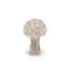 Decorative smooth pale beige stone vase containing lush bouquet of white roses on matching base against clean white