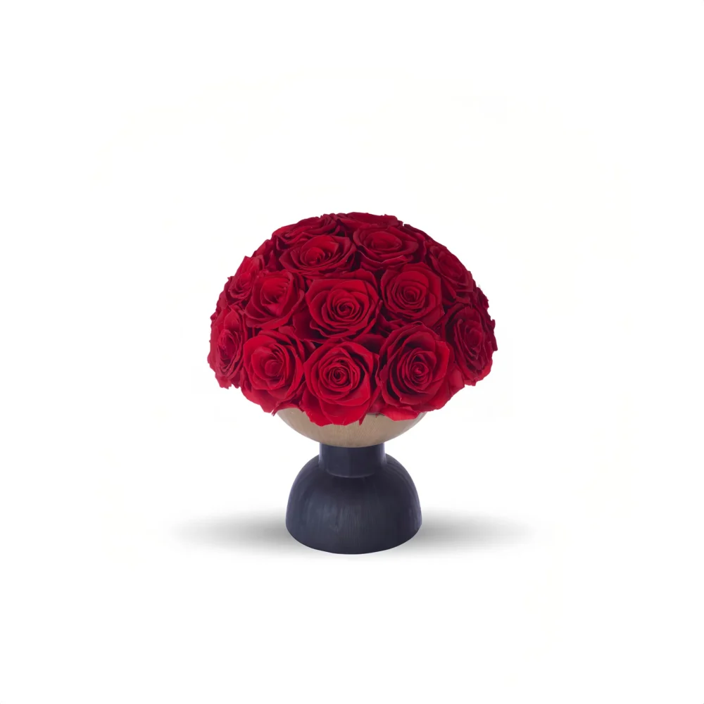 A photograph of a round, black pedestal vase holding a lush, vibrant bouquet of red roses. The roses are densely packed, with rich, velvety petals and dark green leaves peeking through. The vase is simple, modern, and sleek, with a matte finish. The background is stark white, creating a minimalist, elegant aesthetic that emphasizes the vivid red of the roses. The shadows cast by the vase and flowers are subtle, adding depth to the image.high quality, detailed, photograph , hd, 8k , 4k , sharp, highly detailed