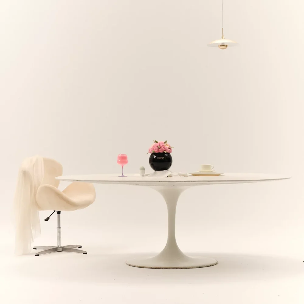 Minimalist dining setup with black vase of pink flowers