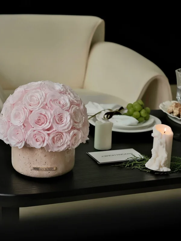 Serene minimalist setting with pink rose floral arrangement in beige vase on black wooden table