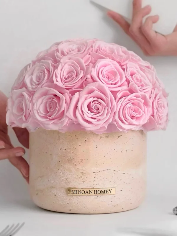 Pink rose bouquet in textured beige vase labeled "MINDAN HONEY" with hands holding white object