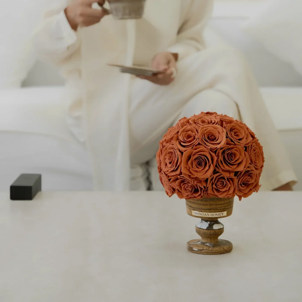 Serene scene with woman in white robe and orange artificial roses