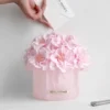 Pink hydrangea bouquet in glass vase with white glove