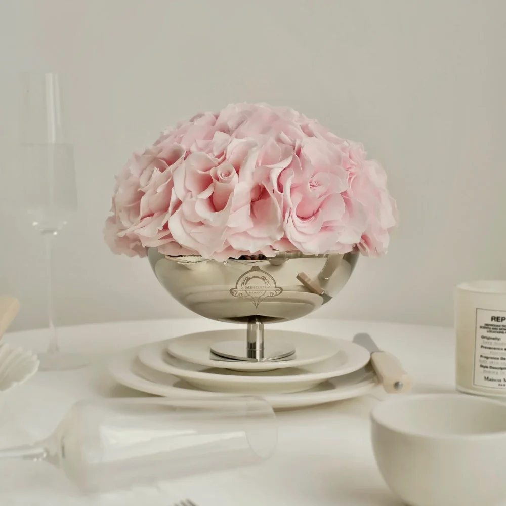 Delicate silver bowl filled with soft pink hydrangeas on elegant table setting