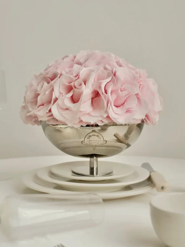Delicate silver bowl filled with soft pink hydrangeas on elegant table setting