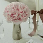 Elegant table setting with silver vase of pale pink roses