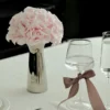 Minimalist table with metallic vase of pink roses and wine glasses