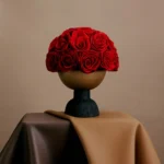 Minimalist floral arrangement with red roses in sleek modern vase