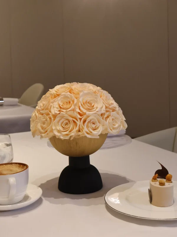 Light wooden vase with cream roses on black base