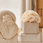 Cream roses on beige marble pedestal