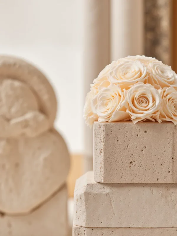 Cream roses on beige marble pedestal
