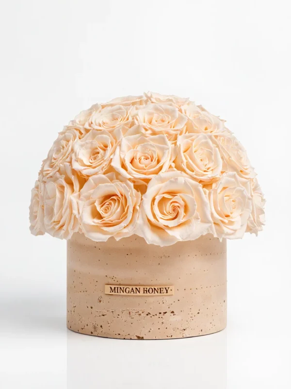 Spherical cream rose arrangement in beige vase