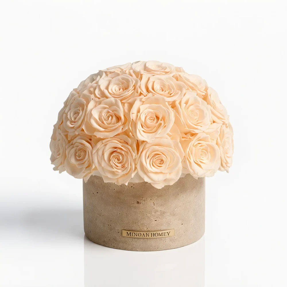 Pale peach roses in a beige cylindrical vase with gold label, minimalist floral design.