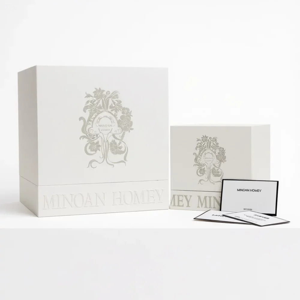 Two large square white boxes with ornate design representing luxury product packaging
